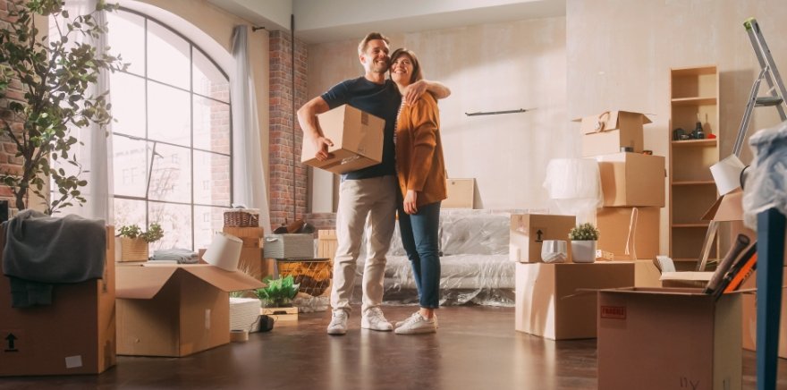 Immobiliensuche – Paar mit Umzugskartons in neuer Immobilie