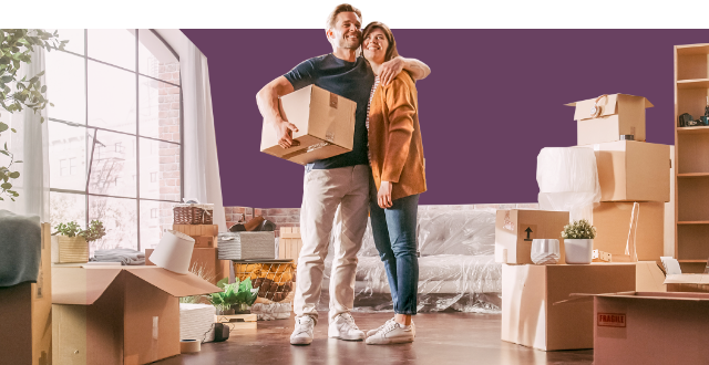 Immobilie suchen – Paar mit Umzugskartons in neuer Immobilie